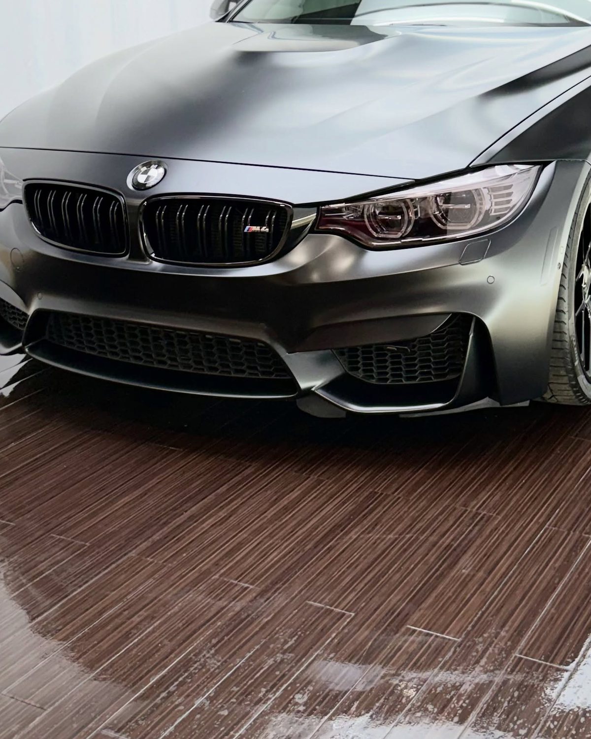 Matte black film across the hood and front end of a BMW M4