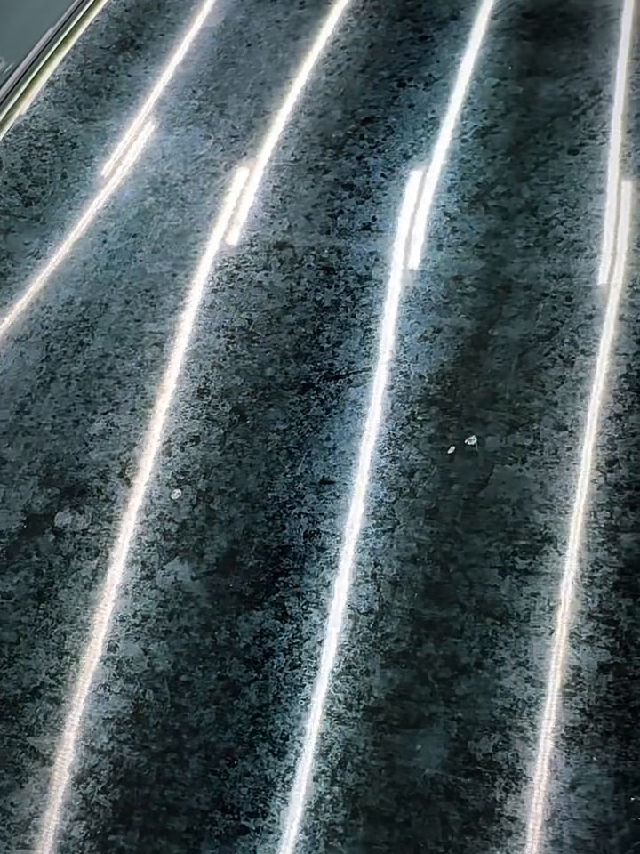 Swirl marks showing under the shop lights on a black Mercedes-AMG before correction