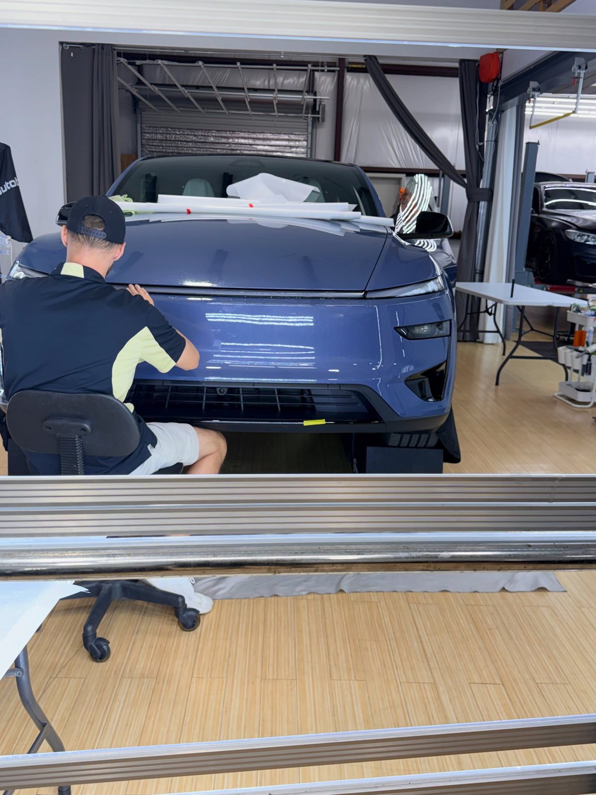 Installer fitting Autobahn PPF to the nose of a 2026 Tesla Model Y Performance