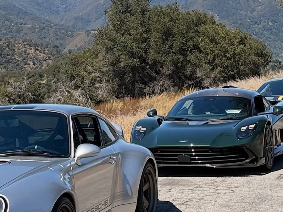 A silver Porsche and the Aston Martin Valhalla on a canyon road
