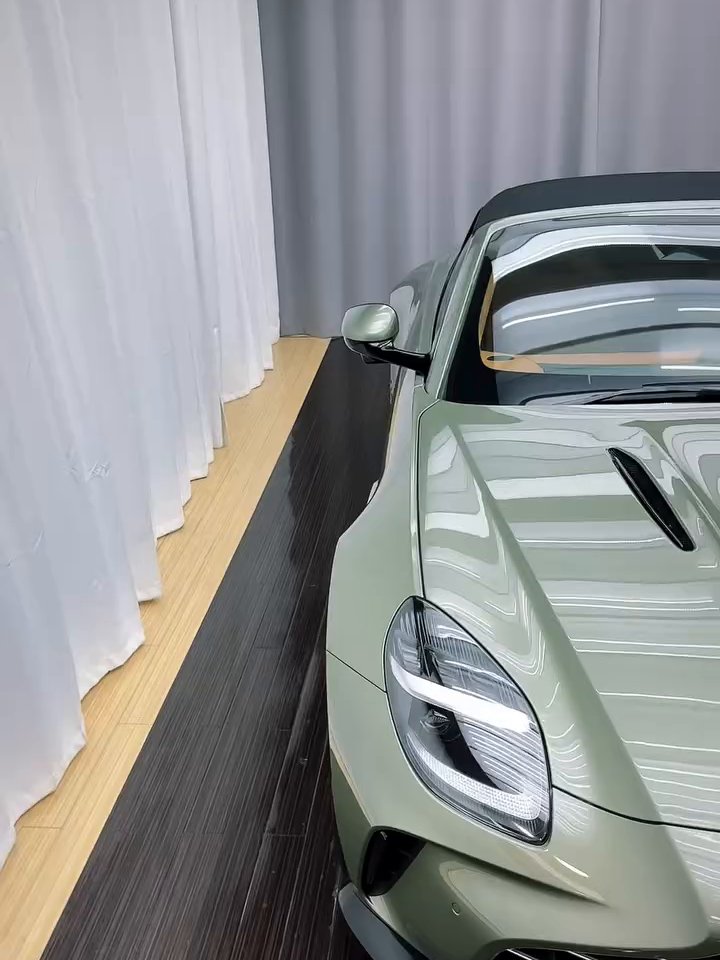The windshield and hood of a sage-green 2026 Aston Martin after its Ultrafit windshield film